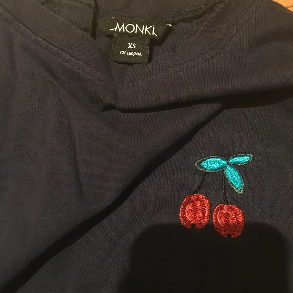 Fin blå långärmad tröja från Monki. Den har knappar bak och en liten körsbär på framsidan och armarna är lite kortare än på en vanlig långärmad tröja. Använd men i bra skick :) . Tröjor & Koftor.