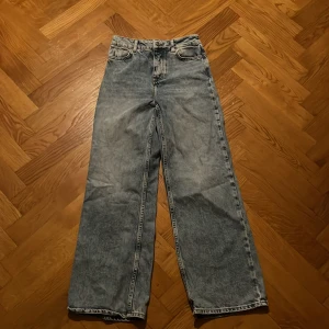 Blå högmidjade jeans  - Blå jeans med knappat istället för gylf Köparen står för eventuell frakt 