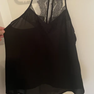 Svart linne med spets  - Svart linne med spets och knapp i nacken 