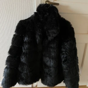 Jacka i fuskpäls - Svart jacka i fuskpäls från Nelly, storlek ca men sitter oversized 