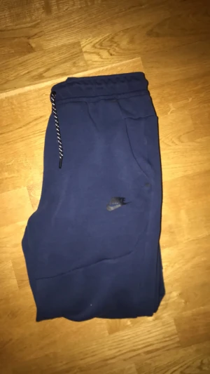 Nike tech fleece byxor  - Hej, jag säljer dessa Nike tec ha fleece byxor. Knappt använda då dem inte riktigt var min stil. Dem är i storlek small. Skriv om ni vill ha fler bilder då dem inte blev så bra!
