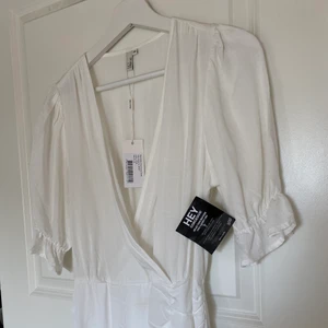 Studentklänning  - En oanvänd studentklänning som är supersöt, omlott i linne. Beställd från Nelly!