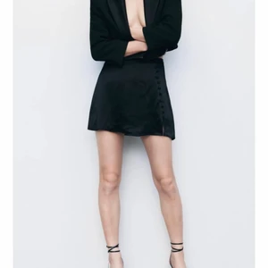 Zara satinkjol  - En svart satin/siden kjol med knappar från Zara💫 Kjolen har shorts under vilket är väldigt praktiskt och bra. Den är i storlek S men skulle även passa en XS eller M🥰 Bara använd 1 gång och köptes för 299kr, säljer nu för 200kr! 