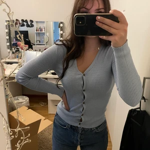 Kofta - Oanvänd ljusblå kofta som går att justera med knapparna. Storleken är XS men koftan är väldigt elastisk så passar därför S och möjligtvis M också. Frakten nedtill behöver inte nödvändigtvis stämma. 