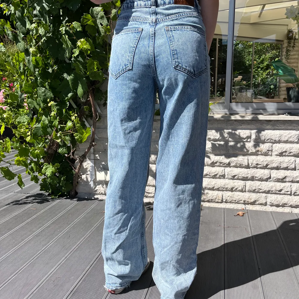 Blå jeans ifårn NA-KD med slitningar nedtill. Bra skick. Passar någon som är runt 165cm lång om man vill att dom ska sitta som på bilden! Köparen står för frakten🫶🏻. Jeans & Byxor.
