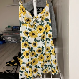 Blommig klänning - Klänning med solrosor  Storlek 36  Knytning över bysten   Aldrig använd 