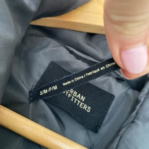 Urban Outfitters Charcoal Wrap Puffer - Oversized puffer jacket, an ideal layer for colder months. Features a high neck, press-stud placket, long sleeves, fitted ribbed cuffs and side pockets. Padded puffer style for maximum warmth and comfort.