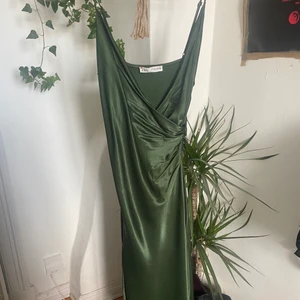 Zara klänning  - Säljer min underbara gröna Zara klänning i satin! strlk S💚Använd en gång på min avslutning förra året. Går omlott över bröstet och har en scrunch i midjan som framhäver figuren! Har även en slit på vänster sida. Inga defekter utom en fläck på lappen men inget på klänningen! ❤️ Köpt för 360kr. Skriv för fler bilder / diskutera pris. Perfekt inför kommande avslutningar!💘💘