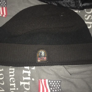 Parajumper mössa - En pjs mössa! väldigt bra skick bara lite solblekt, inga skador eller någoting. Använd rätt länge men den funkar!