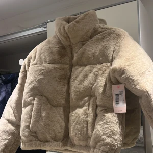 Padded jacka  -  Helt ny oanvänd Pälsjacka i storlek 32, lång ärm med en resår vid ärmsluten. Resår i nederkant