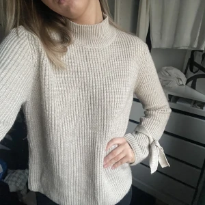 Beige stickad tröja - Beige/brun stickad tröja från Gina Tricot med rosetter på ärmarna🤍