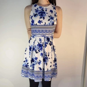 klänning med blåa blommor - helt oanvänd klänning med blåa detaljer i storlek M. den har fina öppna delar vid sidorna upptill (se bilder) och padding vid brösten så man kan skippa BH. längden är ca 85 cm. möter ej upp, postar enbart 🌸