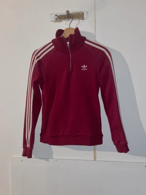 Långärmad Adidas - Varm och skön långärmad adidas tröja som har en snygg röd färg och gömda fickor. Säljer för 100kr eller högsta bud + frakt. 
