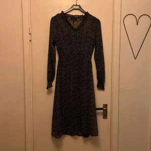 Somrig volangklänning - Jättesöt brun transparant klänning med vita prickar. Svart underklänning. 