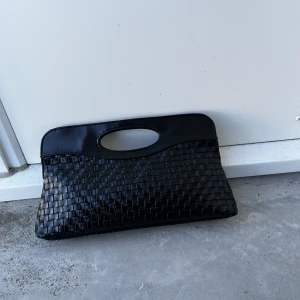 VINTAGE kuvertväska/clutch - Svart vintage clutch med Bottega Veneta mönster säljes. Två st innerfickor varav ena är med dragkedja. Inga skavanker eller dylikt.   Pris: 100 kr, kan fraktas för 69 kr (spårbart) som köparen står för, går även bra att mötas upp i centrala Göteborg. 