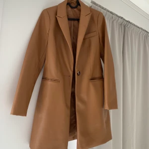 Brun skin kapp - Säljer min fina kappa för den inte passar längre. Jätte fin och figursydd. Inget fel på jackan:)