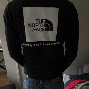 En svart The north face tröja med tryck på baksida. Bra skick.