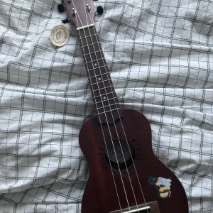 Ukulele  - Säljer en mörkbrun ukulele med humla på, originalpris 400kr och säljer för 150kr. Fint skick och säljer då jag inte använder den längre! ❤️