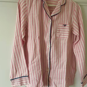 Rosa Pyjamasskjorta  - Rosa pyajamasskjorta i flanelltyg. Storlek 32/34 men skulle även kunna passa storlek 36. Mycket bra skick. Tveka inte att ställa frågor eller få fler bilder <333
