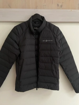 Sail racing jacka  - Säljer nu denna fina och nästan helt nya Sail racing jacka. Jackan är av dun och är perfekt under hela året. Du kan ha en tröja under på vintern eller en t shirt under på en svalare sommarkväll. Jackan är i nyskick och har inga tecken på användning.