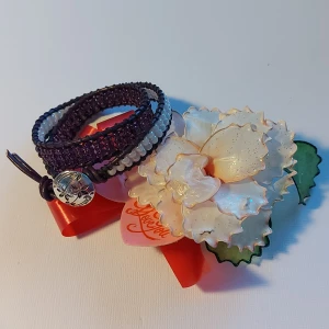 ETT SNYGGT HANDGJORT ARMBAND ATT VIRA RUNT HANDLEDEN  - Armbandet är gjort av skinnrem och pärlor med metallknapp. Den är 35cm lång, räcker till 2 varv runt handleden. Lätt att ta på. En fin påse medföljer Bilderna får tala för sig själva. Frakten betalas av köparen.  