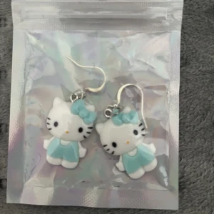 Örhängen  - Ett par helt oanvända hello Kitty örhängen, i original förpackning. Säljes för 30kr + 13kr frakt