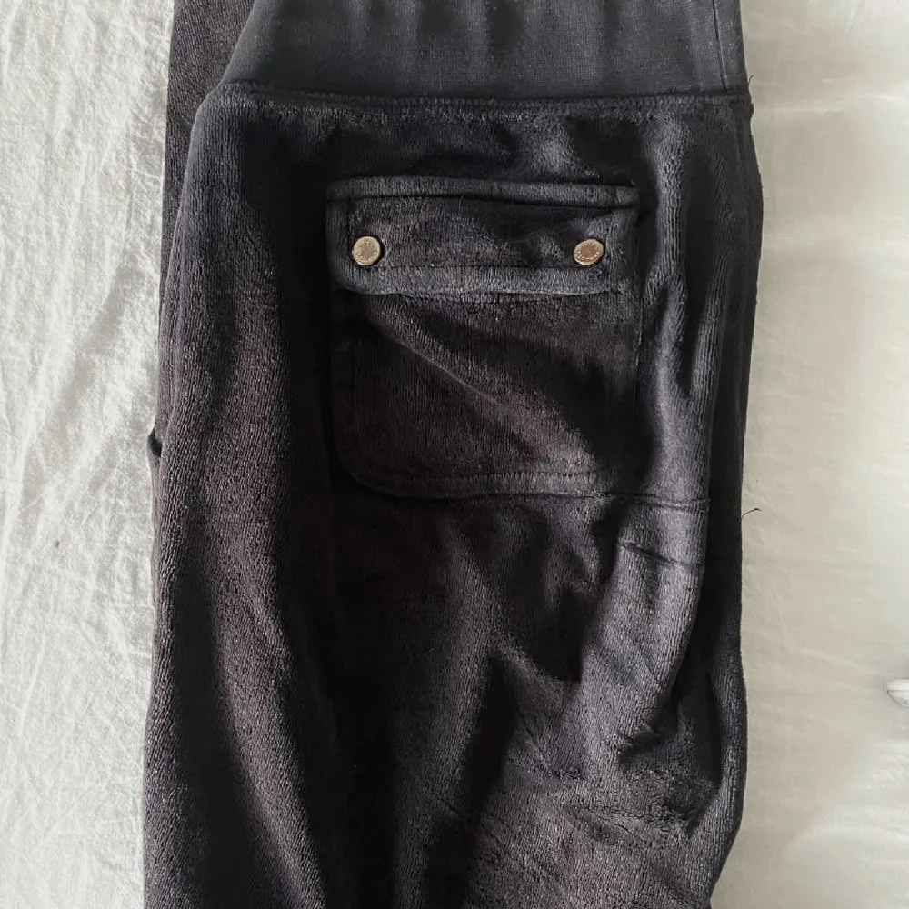 Svarta juicy byxor som jag köpte har på plick, de är i ok skick lite slitna och några fläckar(har inte testat ta bort) en silver detalj på snöret saknat=lågt pris!. Jeans & Byxor.
