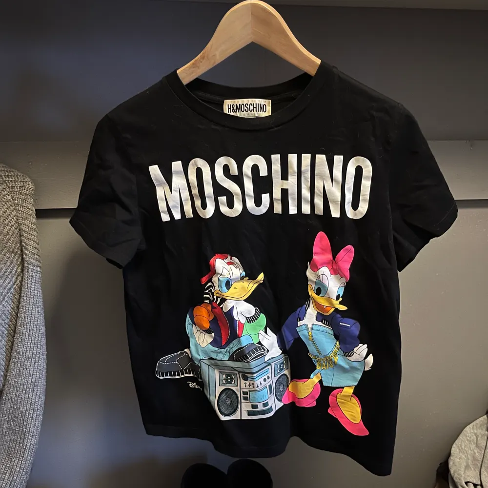 Jättefin tröja från HMs kollektion med Moschino. Tröjan är inte använd så mycket så den är i väldigt fint skick.. T-shirts.