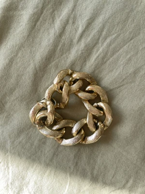 Armband guldkedja - Ett riktigt pråligt armband från 80-talet! Härlig guldkedja men ändå inte så tung. Ej äkta guld såklart utan bijouteri. Inget spänne men man kan lirka upp ”öglorna.”