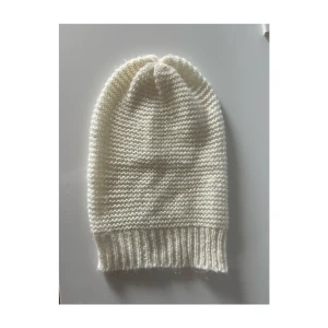 Mössa - Vit stickad ”baggy” mössa, aldrig använd, endast legat i en låda. Finns nån enstaka ögla, men det är bara att peta in den så syns de inte. 