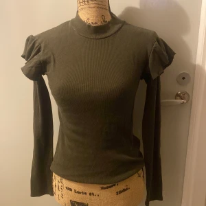 Tröja - Grön lång ärmar tröja med volanger på axlarna Använd en gång