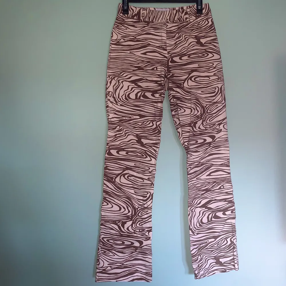 Amazing trippy statement pants köpta på Humana, i felfritt skick🤎🤍 färgerna syns bäst i andra bilden. Uppskattningsvis strl XXS/XS. Midjemått: 62cm Benlängd: 68cm. Jeans & Byxor.