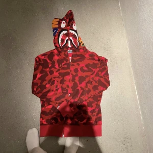 Bape hoodie - Röd bape hoodie som jag köpte här på plick. En väldigt bra replika om man inte vill betala typ 5000kr för en äkta som ser och känns likadan ut