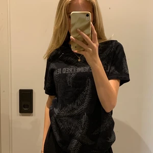 Svart sommartshirt från Levis - Asball Levis t-shirt med insytt mönster av palmblad💕💕 Supernice nu till sommaren men säljer då den inte längre kommer till använding💞 Köpt på herr för 400kr