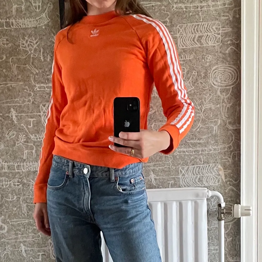 Orange collegetröja från adidas, str 34/36. Passar mig som vanligtvis har str s. Inte använd mycket alls och är fortfarande mjuk i tyget!. Hoodies.
