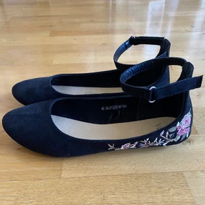 Svarta sammetsskor med brodering  - Ett par svarta ballerinaskor i sammet med broderade blommor på sidan, storlek 40, endast använda en gång på en skolavslutning.