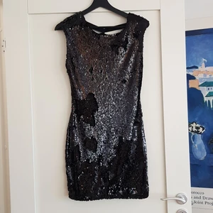 Figurformad piljettklänning öppen rygg - Paljettklänning med öppen rygg, passar dig som gillar figursydda klänningar där mam vill få fram en snygg figur,jag är 170 och den går till halva låren,  nyskick   