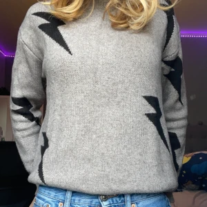 Fin stickad tröja med blixtrar  - Detta är en super snygg stickad tröja med blixtrar på! Den är köpt för 220kr💓. Kom privat för frågor och mer bilder om det behövs. (Tröjan är beige med svarta blixtrar)
