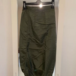 Kjol lång  - Kjol jätte tun i material.har dragskedja back och längs ner på kjolen har snöret  så dra åt  . Har köpt frå år 2000 . Barnstolek 128 men som xs går jätte bra .längd på kjolen är 67cm , midjan är 28cm 