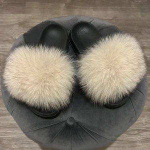 Tofflor  - Säljer dessa super fluffiga päls tofflor med ”smutsvit” päls svart längs kanterna. Väl omhändertagna och lika fina som  nyköpta!