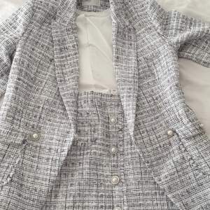 Säljer ett set med jacka och kjol som är inspirerat av Chanels klassiska tweedset. Setet har aldrig använts så det är helt nytt!   Inköpspris: 2200 Kr