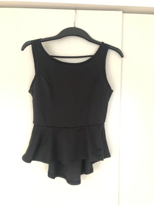 Volangtopp  - Fin topp med öppen rygg och rosett baktill. Lite tjockare material som gör att den sitter snyggt mot kroppen. 