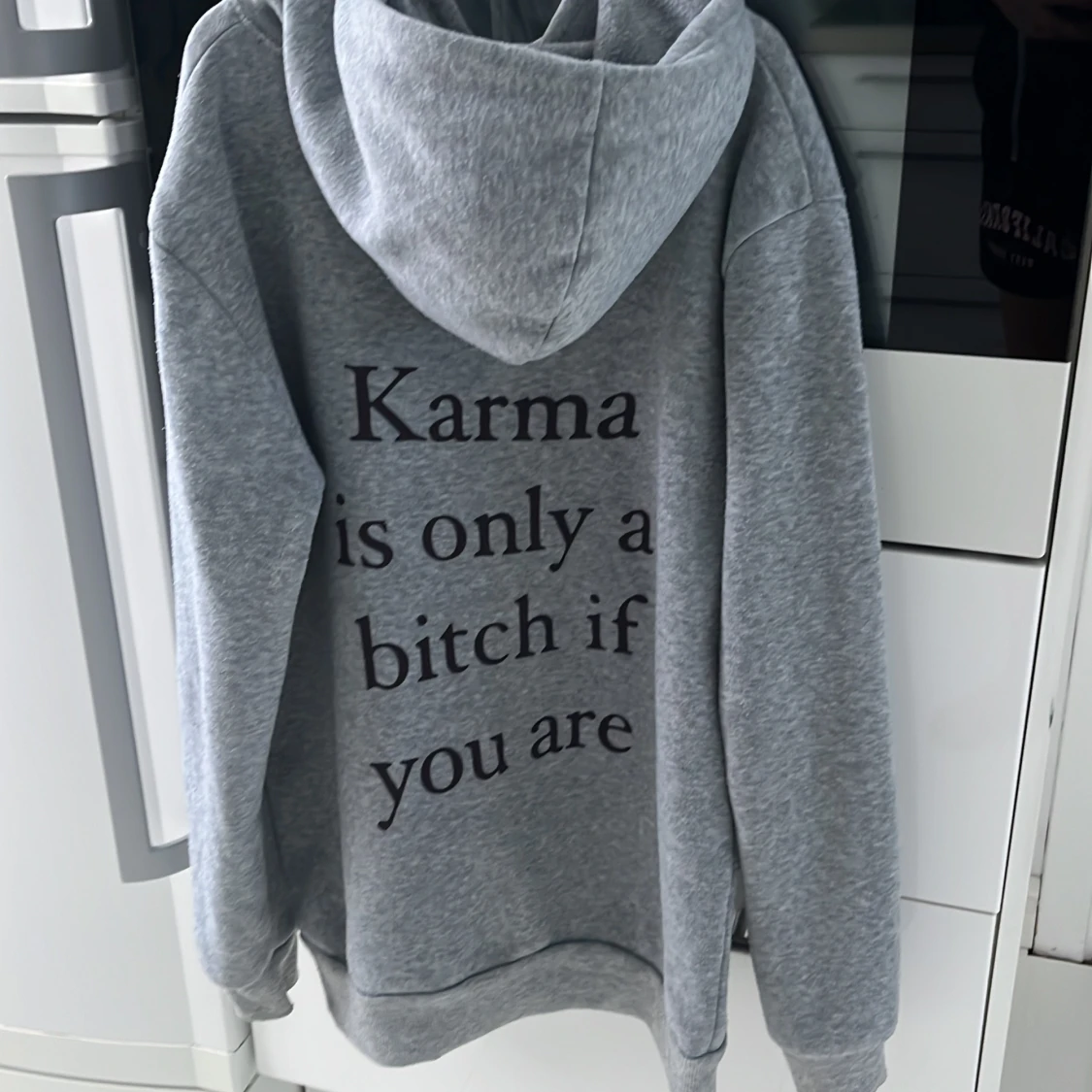 Grå hoodie med text på ryggen