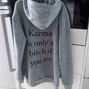 En grå hoodie i bra skick som det står”karma is only a bitch of you are