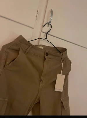 Cargo byxor  - Beige cargo byxor, oanvända i storlek 36 