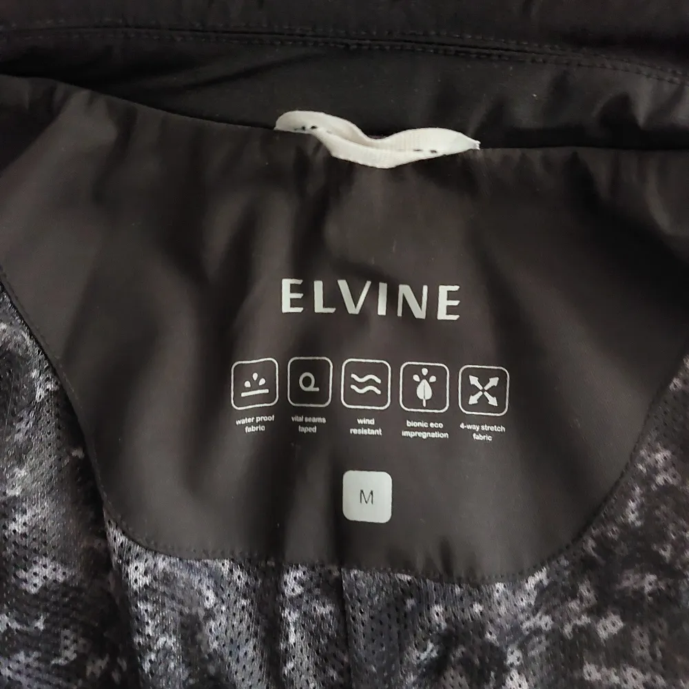 Regnavvisande jacka från Elvine.   Storlek: Medium Skick: 10/10  Material utvändigt: 87% nylon, 13% elastane Material invändigt: 100% polyester . Jackor.