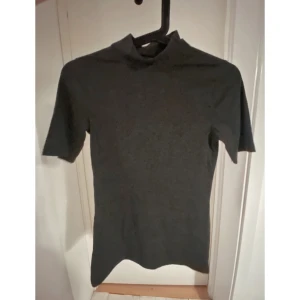 Grå t-shirt med polo - Från Gina tricot. Sparsamt använd. Som ny. Storlek S.