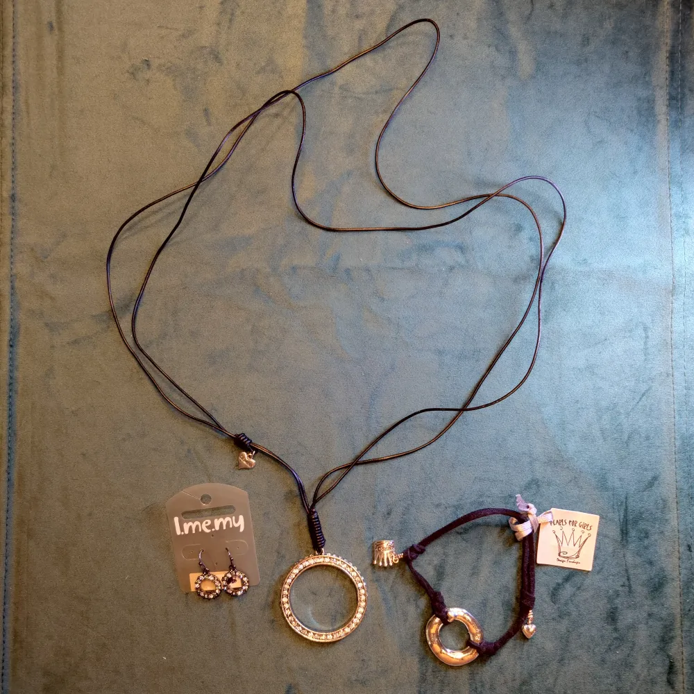 Ett halsband, armband och ett par örhängen med cirklar i svart och silver. Stilrena och snygga! Halsbandet har en tappad sten men är annars använt sparsamt och resten är nytt och oanvänt. 70kr för allt + frakt. . Accessoarer.