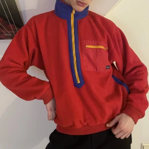 Röd gul blå vintage patagonia fleecetröja  - Röd, gul och mörkblå vintage Patagonia fleecetröja med halfzip, fickor med dragkedjor och ficka på bröstet 🧣Så härlig till de kalla vintermånaderna och som en overshirt till våren! Riktigt härliga 80-tals vibes! 🪩