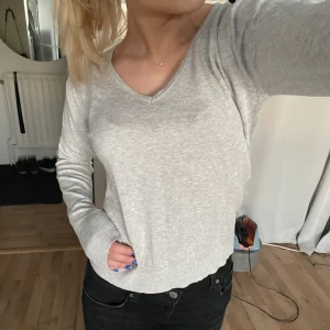 Grå v-ringad stickad tröja! - En jättefin stickad tröja med v-ringning. Köpt på lager 157 och knappt använd. Är i storlek M men passar mig som är S. Säljer för 80!!